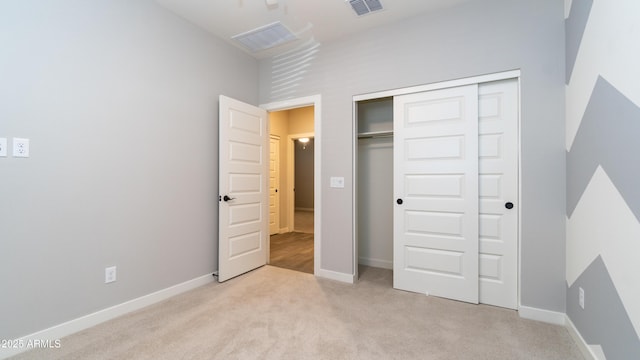 unfurnished bedroom with carpet floors, baseboards, a closet, and visible vents