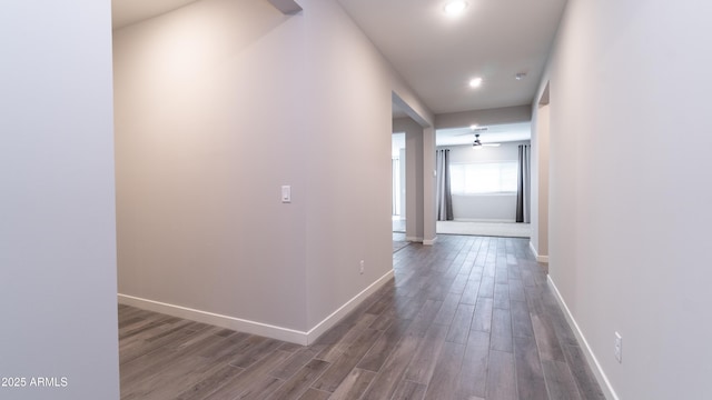 hall featuring recessed lighting, baseboards, and dark wood-style floors