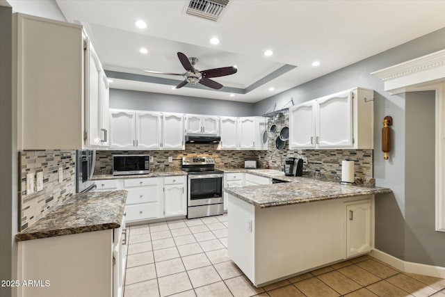 kitchen featuring light tile patterned floors, stainless steel appliances, white cabinets, stone countertops, and kitchen peninsula