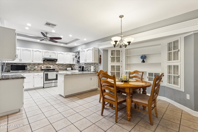 kitchen with pendant lighting, appliances with stainless steel finishes, backsplash, white cabinets, and light tile patterned flooring