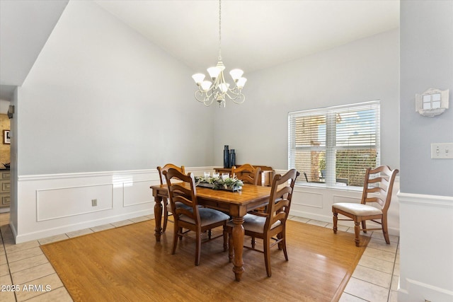 dining area featuring vaulted ceiling, a chandelier, and light tile patterned flooring