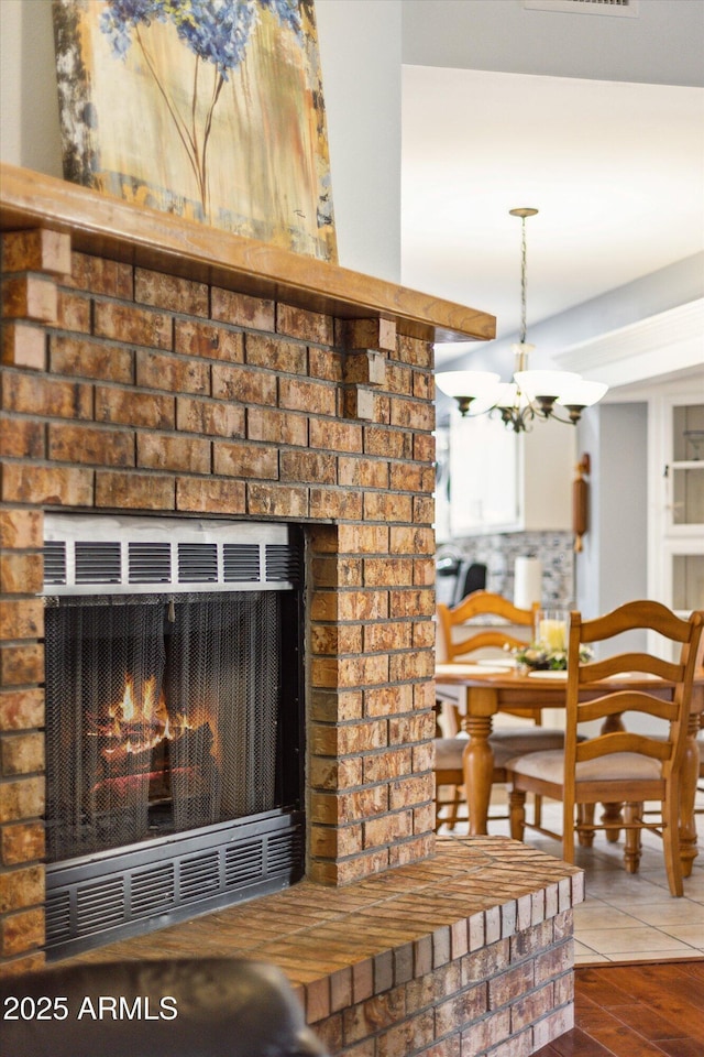 details with a brick fireplace and a chandelier