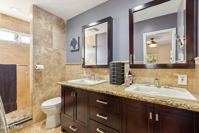 bathroom featuring toilet, an enclosed shower, tile walls, vanity, and ceiling fan