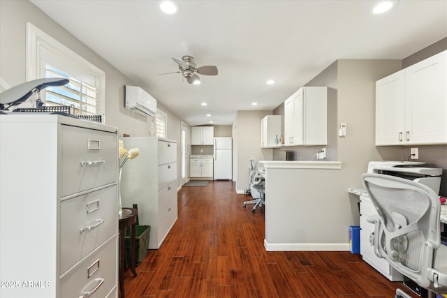 kitchen featuring white cabinetry, dark wood-type flooring, white fridge, and an AC wall unit