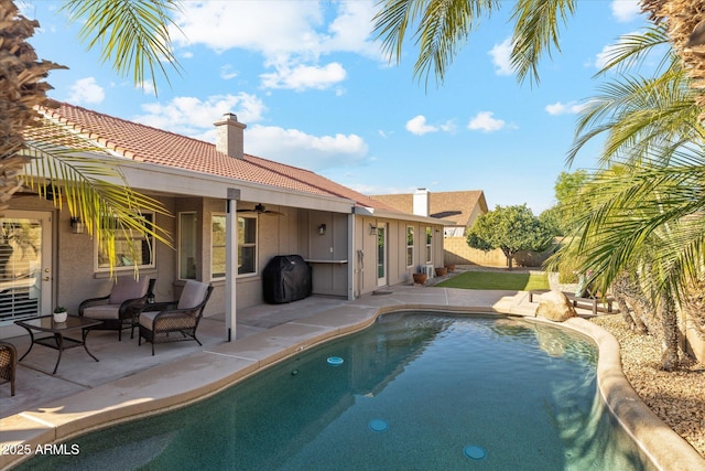 view of swimming pool featuring area for grilling, a patio, and ceiling fan