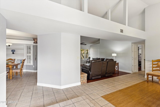 living room featuring light tile patterned flooring and high vaulted ceiling