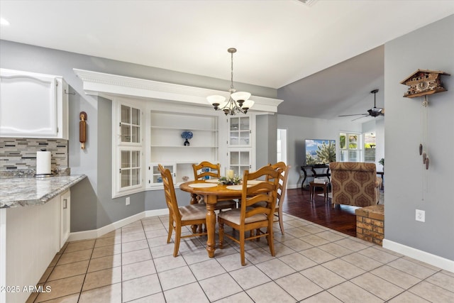 dining room featuring lofted ceiling, light tile patterned floors, and ceiling fan with notable chandelier