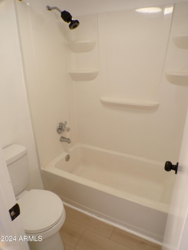 bathroom with tile patterned floors, shower / bathtub combination, and toilet