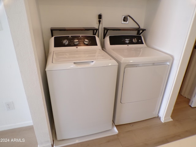 laundry room with light hardwood / wood-style floors and independent washer and dryer