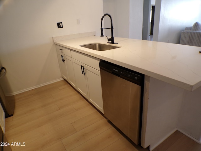 kitchen featuring sink, light hardwood / wood-style flooring, stainless steel dishwasher, kitchen peninsula, and white cabinets