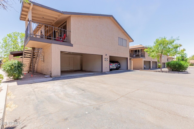 1133 N 84th Pl, Scottsdale, AZ 85257 - view of home's exterior with stairs, stucco siding, a garage, driveway, and a balcony