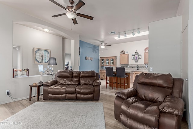 6610 E University Dr Unit 2, Mesa, AZ 85205 - living room featuring a ceiling fan, light wood-type flooring, arched walkways, and track lighting