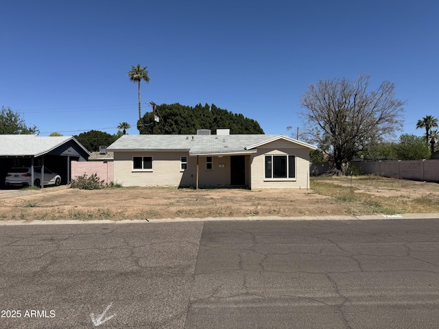 ranch-style house featuring brick siding, a carport, and fence