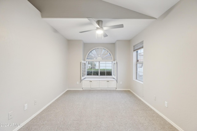 carpeted spare room featuring ceiling fan and lofted ceiling