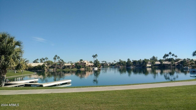 dock area with a lawn and a water view