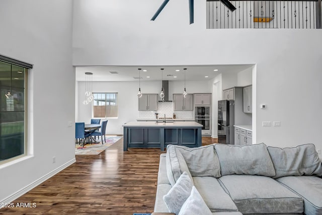 32083 N 126th Ave, Peoria, AZ 85383 - living area with a high ceiling, dark wood-style flooring, ceiling fan, and baseboards