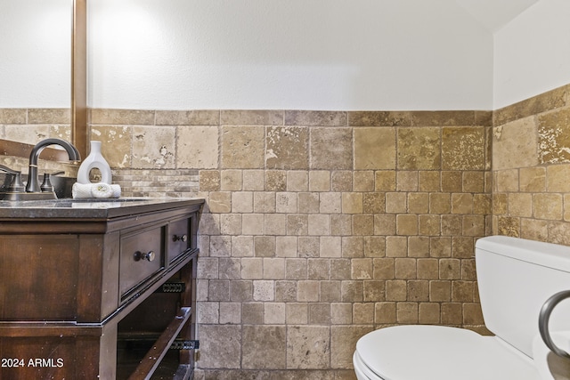 bathroom with tile walls, vanity, and toilet