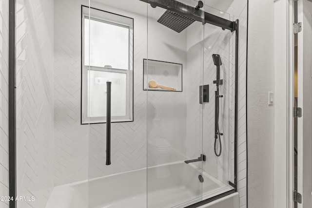 bathroom with combined bath / shower with glass door