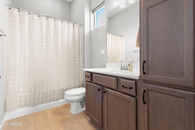 full bathroom featuring shower / tub combo with curtain, vanity, wood-type flooring, and toilet