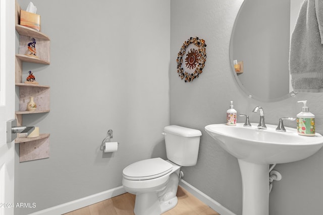 bathroom featuring wood-type flooring and toilet