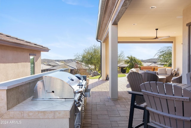 view of patio / terrace with a grill, ceiling fan, and an outdoor kitchen