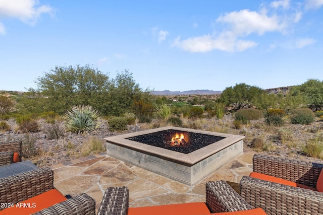 view of patio / terrace with a mountain view and a fire pit