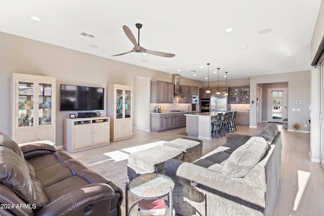 living room with ceiling fan and light hardwood / wood-style floors