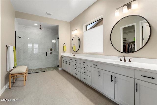 bathroom featuring a shower with door and vanity