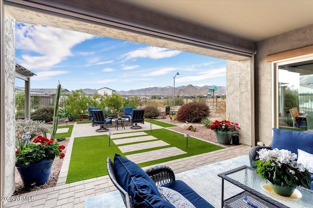 view of patio / terrace featuring an outdoor living space with a fire pit and a mountain view