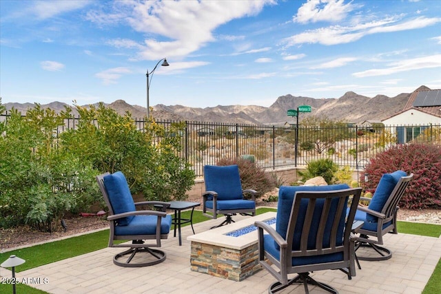 view of patio featuring an outdoor fire pit and a mountain view