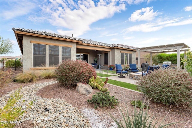 rear view of house with a pergola, a fire pit, and a patio