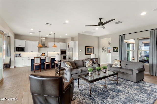 living room featuring light hardwood / wood-style floors and ceiling fan