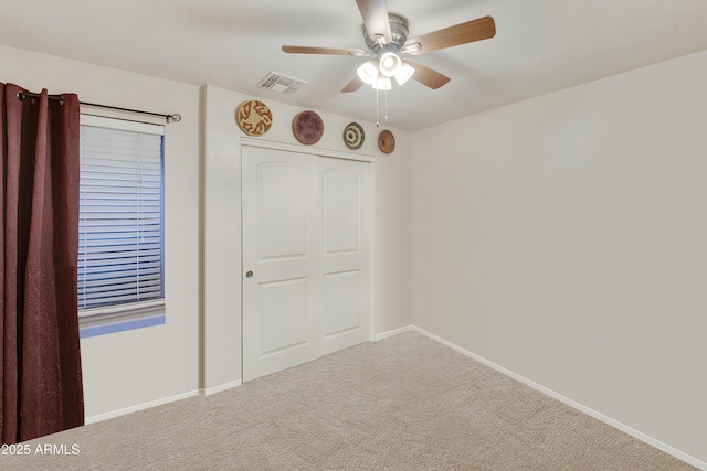 unfurnished bedroom featuring carpet floors, a closet, and ceiling fan