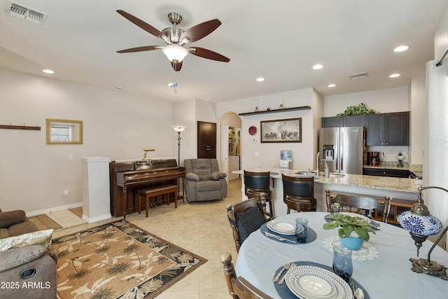 tiled dining space with ceiling fan and sink