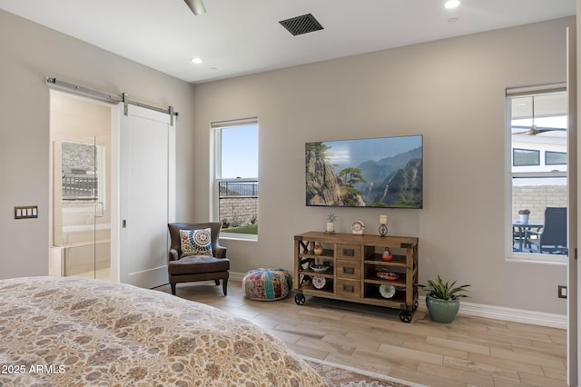 14507 N Valencia Dr, Fountain Hills, AZ 85268 - bedroom featuring a barn door, wood finished floors, baseboards, recessed lighting, and ensuite bath