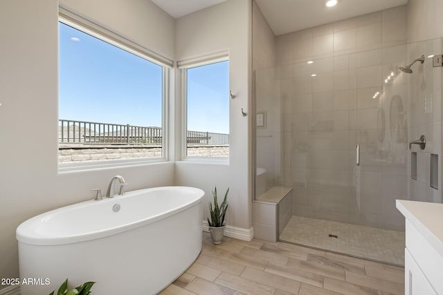 14507 N Valencia Dr, Fountain Hills, AZ 85268 - bathroom with a stall shower, a freestanding tub, wood finish floors, baseboards, and recessed lighting