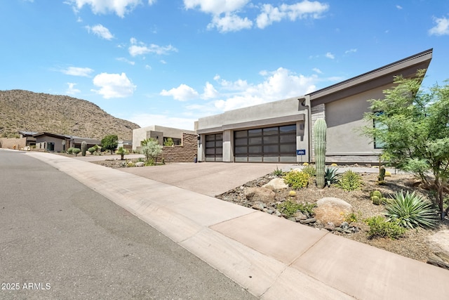 14507 N Valencia Dr, Fountain Hills, AZ 85268 - view of front of home featuring stucco siding, an attached garage, concrete driveway, and a mountain view