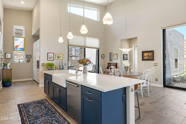 14507 N Valencia Dr, Fountain Hills, AZ 85268 - kitchen with a sink, stainless steel dishwasher, a towering ceiling, blue cabinetry, and a breakfast bar