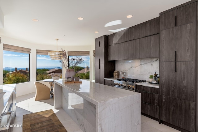 kitchen featuring light tile patterned flooring, pendant lighting, tasteful backsplash, stove, and a center island