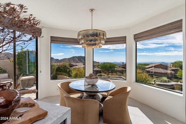 sunroom / solarium featuring a mountain view and an inviting chandelier