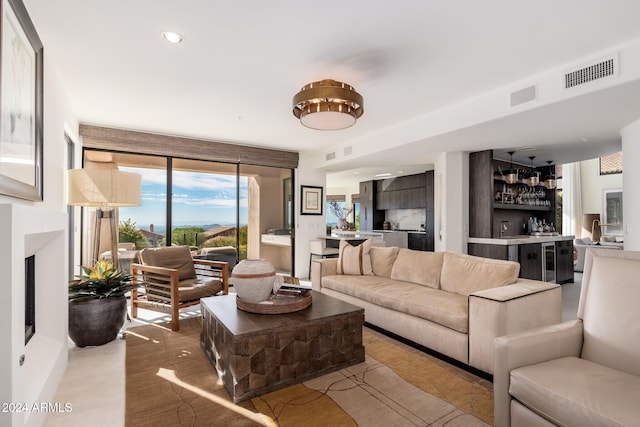 living room featuring indoor bar and light hardwood / wood-style flooring