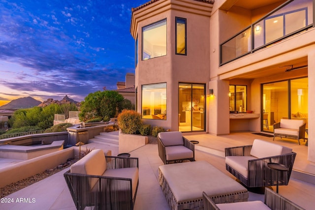 patio terrace at dusk featuring an outdoor living space and a mountain view