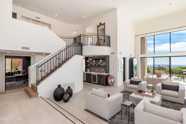 living room featuring bar, a mountain view, light tile patterned floors, and a high ceiling