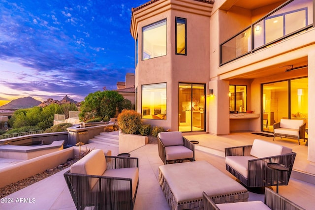 patio terrace at dusk featuring an outdoor living space and a mountain view