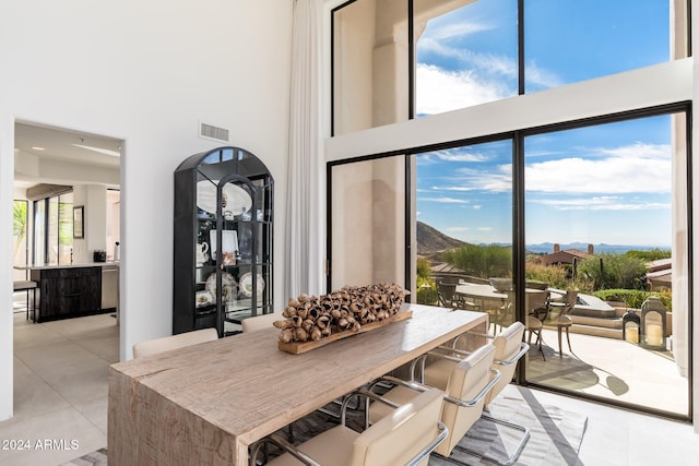 interior space featuring a mountain view, a towering ceiling, and light tile patterned floors