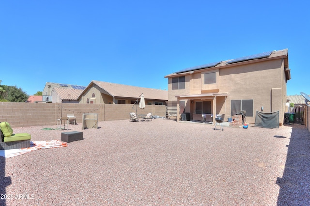 rear view of house featuring a patio area and solar panels