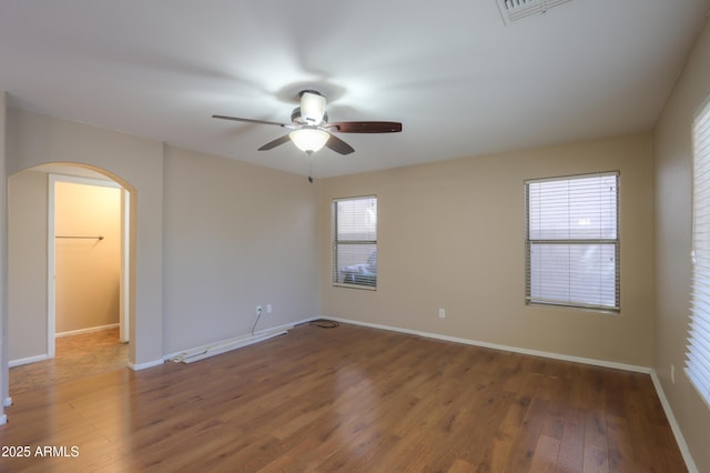 spare room with ceiling fan, plenty of natural light, and dark hardwood / wood-style flooring