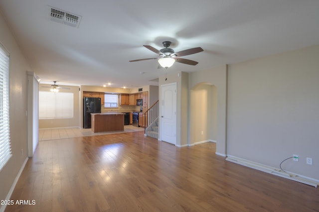 unfurnished living room with ceiling fan and light hardwood / wood-style flooring