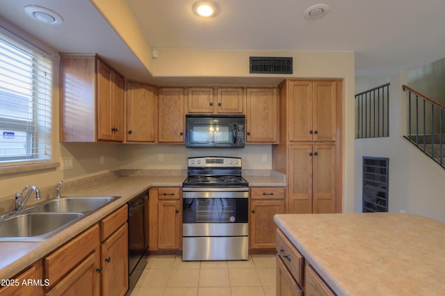 kitchen with light tile patterned floors, sink, and black appliances