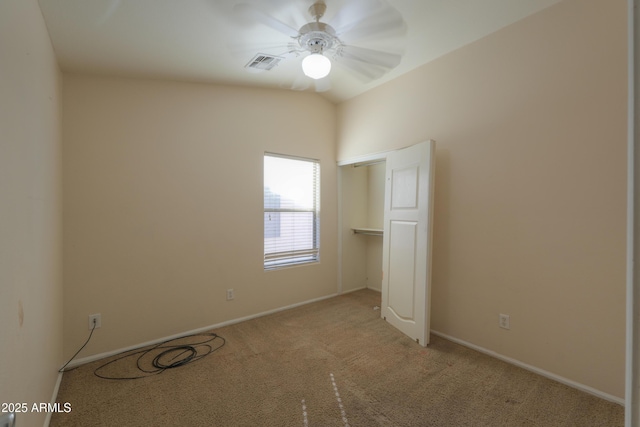 empty room featuring ceiling fan and light carpet